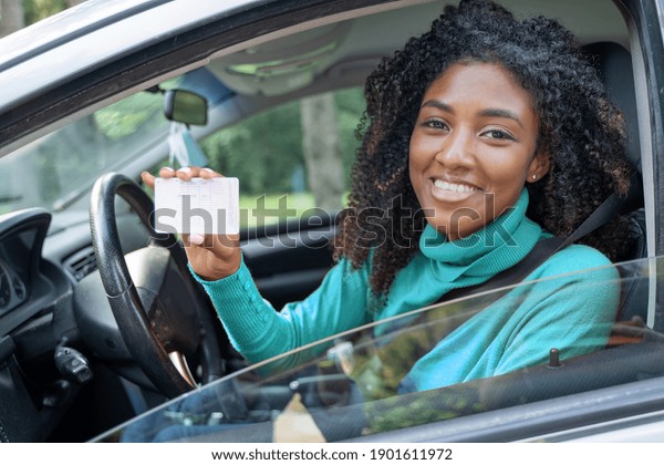 New car owner.\
Happy woman showing car\
license