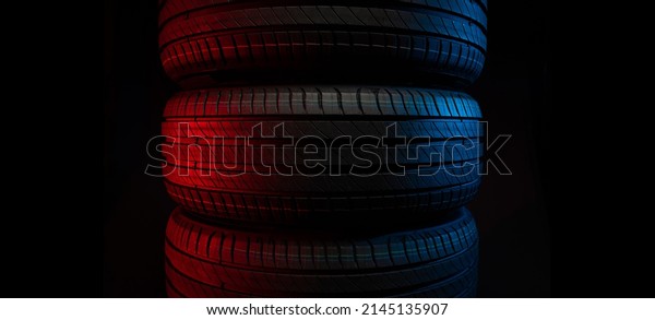 New
car tires. Group of road wheels on dark background. Summer Tires
with asymmetric tread design. Driving car
concept.