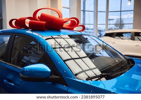 The new car is wrapped in a red bow. Beautiful gift concept