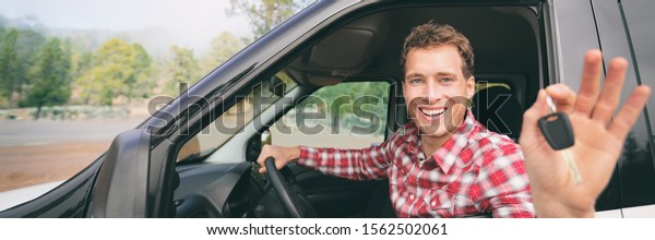 New car young man driver happy holding keys\
driving rental on road trip vacation travel holiday banner\
panoramic background. Drive\
lifestyle.