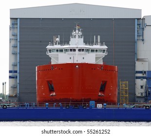 New Cargo Ship In Front Of A Shipyard Hall