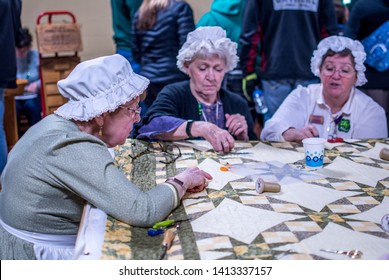 New Carlisle Indiana USA March 17, 2019 ; At The  Bendix Wood Sugar Camp Days Event, Women In Old Fashioned Costumes Hold A Quilting Bee At This Fun Demonstration