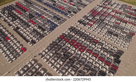 New Cars Located At The Factory Parking Lot Aerial View At Golden Hour. Car Manufactory Parking Area For A New Hybrid EV. High Tech Green Electric Vehicles Sorted After Industrial Production Conveyor.