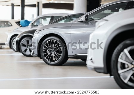 New cars in the showroom show waiting for sale to customer. Luxury modern cars for sale. Cars waiting for sales of branch dealers and new car service center.