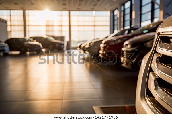 New cars at\
sunlit dealer showroom close\
view