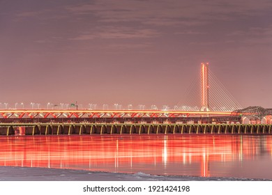 New Champlain Bridge illuminated in red for Valentine's Day in Montreal, Quebec, Canada. Red reflections can be seen on the St-Lawrence river in winter with snow and ice all around.