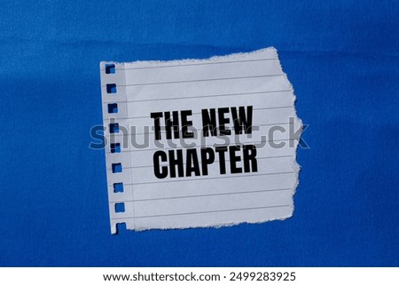 The new chapter message written on ripped torn paper piece with blue background. Conceptual the new chapter symbol. Copy space.