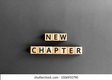 new chapter - words from wooden blocks with letters, starting new life new chapter concept,  grey background