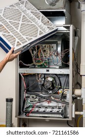 New Clean Filter Is Being Inserted Into A Home Furnace