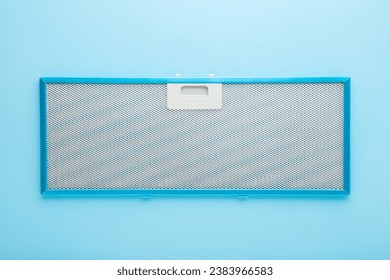 New clean kitchen cooker hood filter on light blue table background. Pastel color. Closeup. Top view.