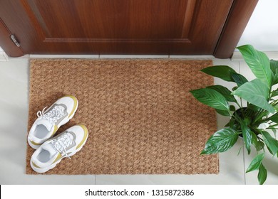 New Clean Mat With Shoes Near Entrance Door And Houseplant, Top View