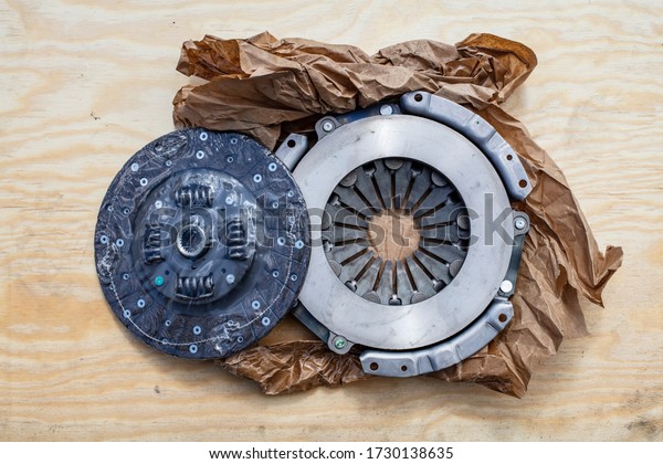New Clutch disc and Clutch cover on top of a\
wooden plate in Finland.