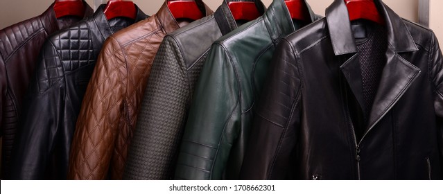 New collection of different color spring leather jackets for men. Colorful background of modern spring, autumn outerwear. Close up. Seasonal clothing in store on sale.