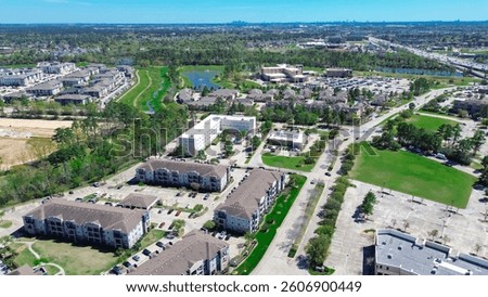 New construction apartment complex and lakeside townhouse with Cypress Creek, Texas State Highway 249 Tomball Parkway background, unincorporated northwestern Harris County, Greater Houston, aerial. US