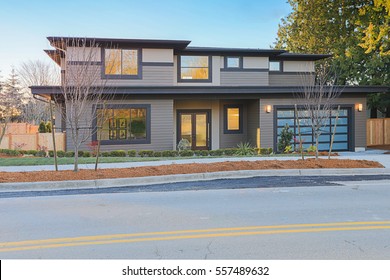 New Construction Home Exterior With Contemporary House Plan  Features Low Slope Roof, Brown Siding And Glass Garage Door. Northwest, USA