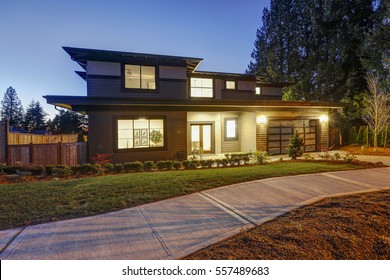 New Construction Home Exterior With Contemporary House Plan  Features Low Slope Roof, Brown Siding And Glass Garage Door. Sunset View. Northwest, USA