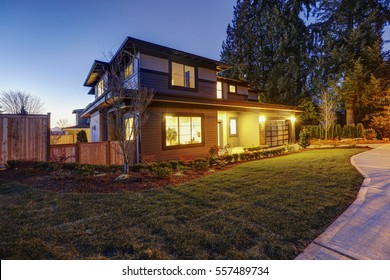 New Construction Home Exterior With Contemporary House Plan  Features Low Slope Roof, Brown Siding And Glass Garage Door. Sunset View. Northwest, USA