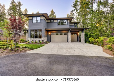 New Construction Home Exterior With Contemporary House Plan  Features Gray Wood Siding, Stone Columns And Two Garage Spaces. Northwest, USA