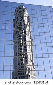 A new construction tower reflected in a blue glass office building