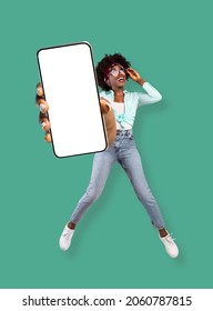 New cool mobile app, special offer. Jumping young curly black lady showing smartphone with empty screen on turquoise studio background, mockup for your website or advertisement