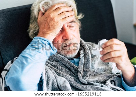 New coronavirus CoVid-19 outbreak situation with pandemic epidemic warning - adult caucasian senior old man with fever symptoms like illness cold seasonal influenza - people and virus concept