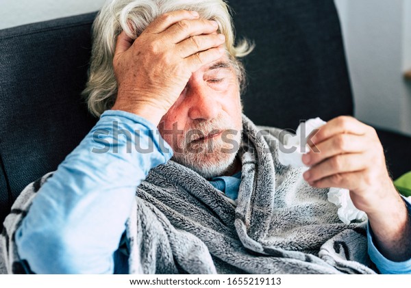 New coronavirus CoVid-19 outbreak situation with\
pandemic epidemic warning - adult caucasian senior old man with\
fever symptoms like illness cold seasonal influenza - people and\
virus concept