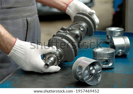 New crankshaft close-up. A set of engine pistons on the car mechanic's desktop. Quality control of spare parts. Car engine repair.