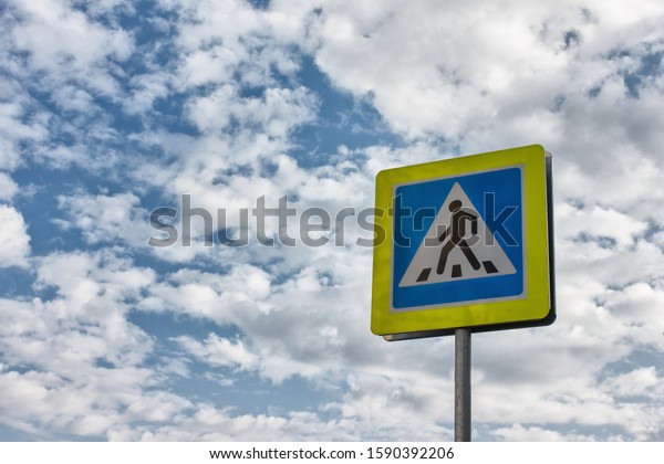 New crosswalk road sign on blue sky\
background. Concept of road safety, road\
accident