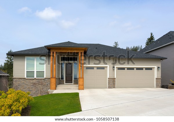 New custom\
built house in Happy Valley Oregon suburban neighborhood with three\
car garage and manicured front\
lawn