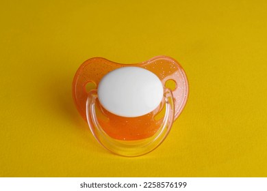 New cute baby pacifier on yellow background - Shutterstock ID 2258576199