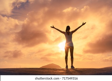 It's a new day. Happy woman with arms up at sunset.  - Powered by Shutterstock