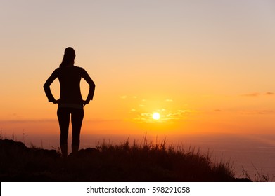 New day and life goals concept. Woman watching the sunrise.