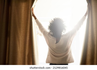 New Day, New Possibilities. Rearview Shot Of A Woman Opening The Curtains On A Bright Sunny Day.