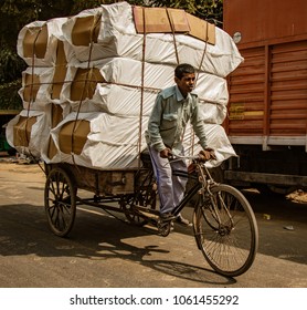 New Dehli, India, Feb 19, 2018: Man carrying massive load on bicycle in India