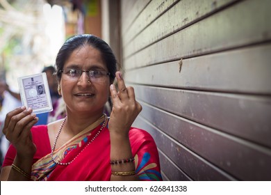 New Delhi - APRIL 23, 2017: New Delhi Elections 2017
A Woman Shows Her Ink Stained Index Finger And Voter Card After Casting Her Vote For The MCD Elections 2017 At A Polling Booth In New Delhi, India.