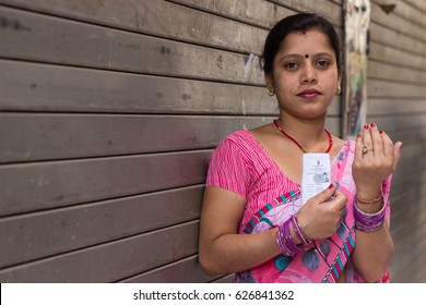 New Delhi - APRIL 23, 2017: New Delhi Elections 2017
A Woman Shows Her Ink Stained Index Finger And Voter Card After Casting Her Vote For The MCD Elections 2017 At A Polling Booth In New Delhi, India.