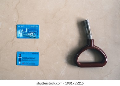 New Delhi, Delhi, India - 07.20.2019: Both Sides Of Delhi Metro Rail Smart Travel Cards With A Train Standing Handle. Metal Passenger Support Grip And Traveller Access Cards Flat Lay Image.