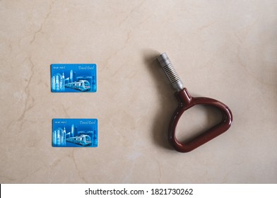 New Delhi, Delhi, India - 07/20/2019: Two Delhi Metro Rail Smart Travel Cards Along With A Train Standing Handle. A Metal Handhold Support Strap And Indian City Commute Access Card Flat Lay.