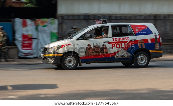 New Delhi, India, 21 May 2021: In Blurred motion vehicle\
of Delhi Tourist Police on city street of New Delhi, going on call.\
