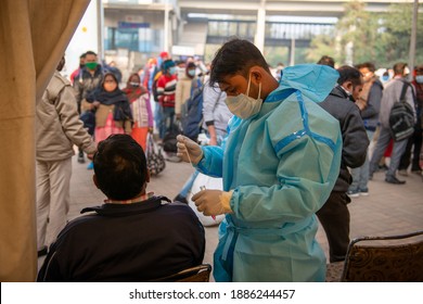 New Delhi, India, 30 December 2020: A Health Worker In PPE Kit And Mask  Taking Nasal Swab Sample To Test For Covid-19 At A Free Coronavirus Testing Camp Anand Vihar.