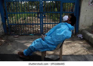 New Delhi, India, April 08, 2021: A Health Worker Wearing PPE Kit Takes Rest After Collects Covid-19 RT-PCR Test To Amid The Spread Of Coronavirus Pandemic.