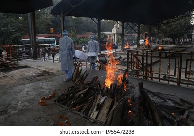 New Delhi, India, April 14, 2021: COVID 19 Death In Indian, Relatives Carry A Body Of Coronavirus (Covid-19) Victim On A Funeral Pyre For His Cremation At A Nigambodh Ghat Crematorium.