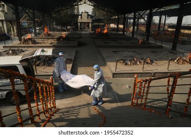 New Delhi, India, April 14, 2021: COVID 19 Death In Indian, Relatives Carry A Body Of Coronavirus (Covid-19) Victim On A Funeral Pyre For His Cremation At A Nigambodh Ghat Crematorium.