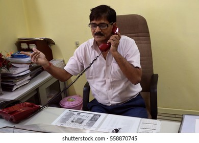 New Delhi, India - April 2, 2016: An Unidentified  Senior Offecial Chatting On Land Line Telephone In His Office.