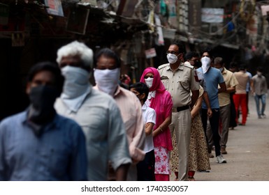 NEW DELHI, INDIA - APRIL 20, 2020: Mobile Covid-19 Testing Van In India, Delhi Police Cop Along With People Stands In A  Queue For Coronavirus Covid 19 Test At Red Zone Area, Old Delhi.