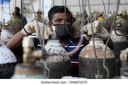 New Delhi, India, April 21, 2021: Worker refilling medical oxygen cylinder for Covid-19 infections patients at a gas supplier filling station during the second wave of coronavirus Covid-19 pandemic.