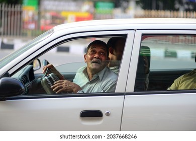 New Delhi, India- Aug 23 2019: Elderly Senior Adult Man Sitting In Car Having Fun Making Funny Faces, Carpool By Office Colleagues Save Oil And Less Pollution.