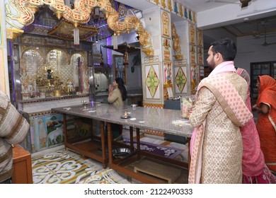 New Delhi, India - Feb 07 2020: A Newly Wedded Couple Praying In Jain Temple Asking The Blessings From The God. Indian Groom Dressed In Ivory Sherwani And Stunning Bride Pink Lehenga. Indian Wedding.