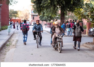 New Delhi / India - February 16, 2020: Two Old Men Riding Motorcycle And Security Guard Riding Bicycle Inside University Campus