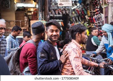 New Delhi / India - February 18, 2020: Portrait Of Three Young Indian Men Riding A Motorcycle Looking At The Camera In Alleys Of Old Delhi